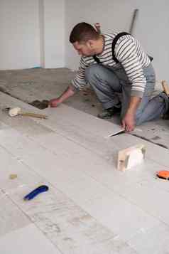 工人安装陶瓷木效果瓷砖地板上