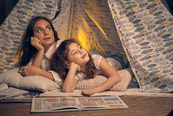 妈妈。女儿坐着超视距雷达帐篷枕头阅<strong>读故事</strong>快乐家庭