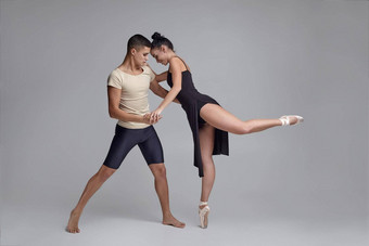 运动现代芭蕾舞舞者摆姿势灰色的工作室背景