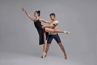 运动现代芭蕾舞舞者摆姿势灰色的工作室背景
