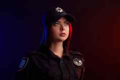 特写镜头拍摄女警察官摆姿势相机黑色的背景红色的蓝色的背光
