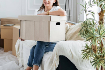 年轻的女人纸板盒子坐着沙发生活房间