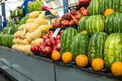 很多大绿色西瓜站橙子水果超市架子上