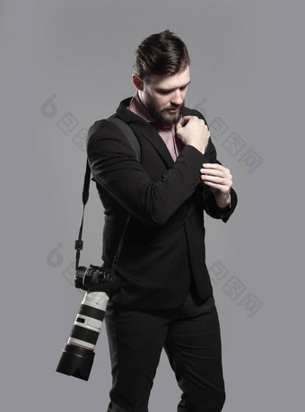 专业摄影师相机调整袖扣孤立的灰色背景