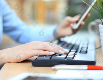 特写镜头女手打字键盘聪明的电话桌子上办公室