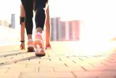 年轻的健身有吸引力的运动女孩跑者开始位置户外日落日出城市