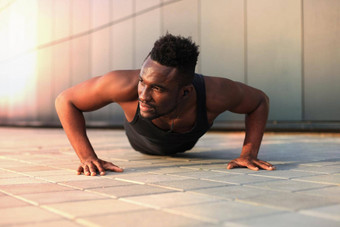 非洲男人。体育服装保持板材位置锻炼在户外