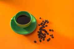 绿色杯咖啡烤咖啡豆子橙色背景