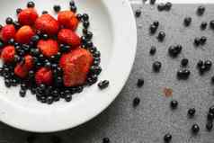 多汁的新鲜的成熟的红色的浆果黑莓谎言白色陶瓷板表格
