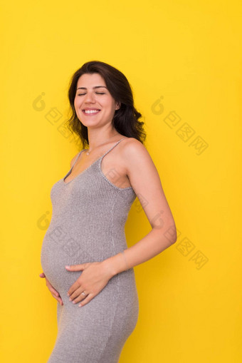 肖像怀孕了女人黄色的背景