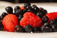 多汁的新鲜的成熟的红色的草莓浆果谎言白色陶瓷板表格明亮的阳光