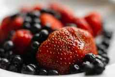 多汁的新鲜的成熟的红色的浆果黑莓谎言白色陶瓷板表格