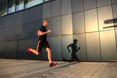 运动年轻的男人。运行在户外保持健康的日落日出跑步者