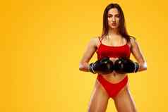运动员女人拳击手战斗手套黄色的背景拳击健身概念