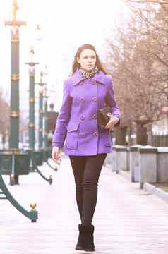美丽的女孩走街紫色的外套清晰的时间一天