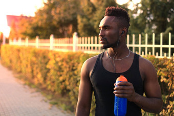 非洲男人。体育服装喝水站日落日出跑步者