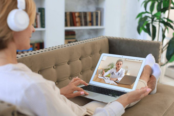 中间岁的女人使视频调用医生隔离检疫在线咨询病人视频会议一般医生移动PC