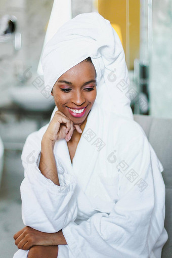 年轻的可爱的非洲式发型美国女孩坐着<strong>浴</strong>室穿<strong>白色浴袍</strong>