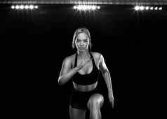 短跑运动员适合运动员跑步者运行黑色的背景概念健康的生活方式体育运动女人黑色的白色运动服装