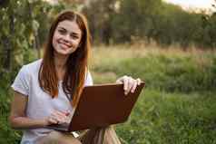 快乐的女人在户外笔记本电脑沟通互联网娱乐