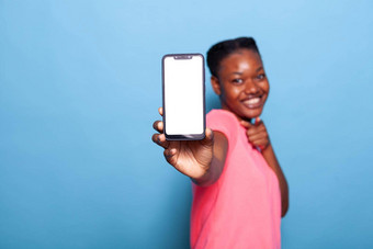 肖像微笑非洲美国年轻的女人显示智能手机
