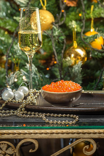 红色的<strong>鱼子酱</strong>陶瓷碗银珠子珍珠玻璃香槟银托盘圣诞节一年背景