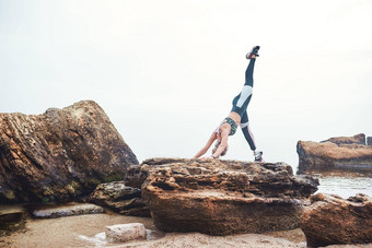 瑜伽早....健康的运动禁用运动员女人运动服装假体腿站瑜伽石头前面海