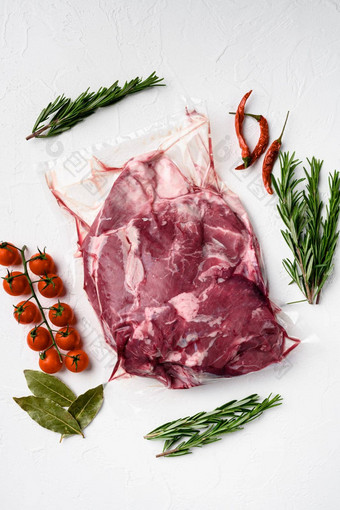 一块生羊肉肉成分草本植物白色石头表格背景前视图平躺