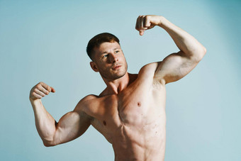 健美运动员肌肉发达的身体摆姿势<strong>新闻蓝色</strong>的背景