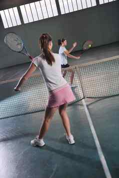年轻的女孩玩网球游戏室内