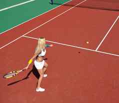 年轻的女人玩网球游戏户外