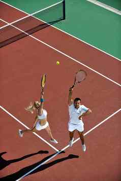快乐年轻的夫妇玩网球游戏户外