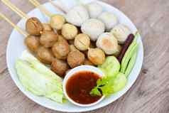 亚洲泰国食物烤肉丸鱼丸porkball辣的酱汁肉丸串白色板新鲜的蔬菜卷心菜院子里长豆黄瓜