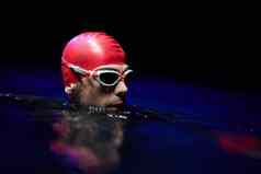 真实的铁人三项选手游泳运动员打破硬培训晚上