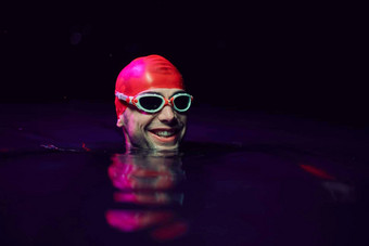 真实的铁人三项选手游泳运动员打破硬培训晚上霓虹灯过来这里光