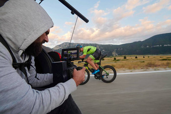 摄影师采取行动拍摄三项全能运动自行车运动员