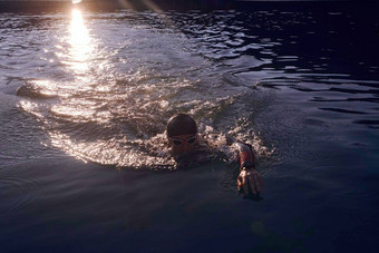 三项全能运动运动员<strong>游泳</strong>湖日出穿潜水服