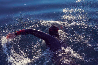 三项全能运动运动员<strong>游泳</strong>湖日出穿潜水服