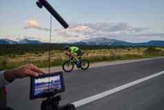 摄影师采取行动拍摄三项全能运动自行车运动员