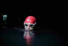 真实的铁人三项选手游泳运动员打破硬培训晚上