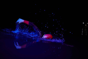 真正的三项全能运动运动员游泳黑暗晚上