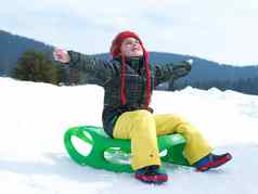 快乐年轻的男孩有趣的冬天vacatioin新鲜的雪