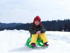 快乐年轻的男孩有趣的冬天vacatioin新鲜的雪