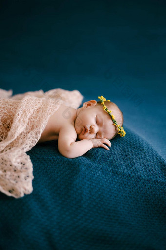 婴儿黄色的花环睡觉覆盖粉红色的披肩