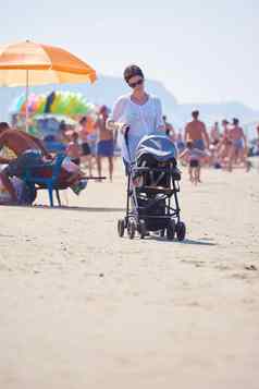 妈妈。走海滩推婴儿马车