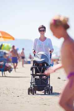 妈妈。走海滩推婴儿马车