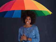 非洲美国女人持有色彩斑斓的伞