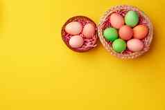装饰巢色彩斑斓的复活节鸡蛋黄色的背景