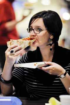 女人吃披萨食物餐厅