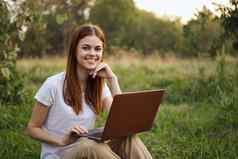 快乐的女人在户外笔记本电脑沟通互联网娱乐